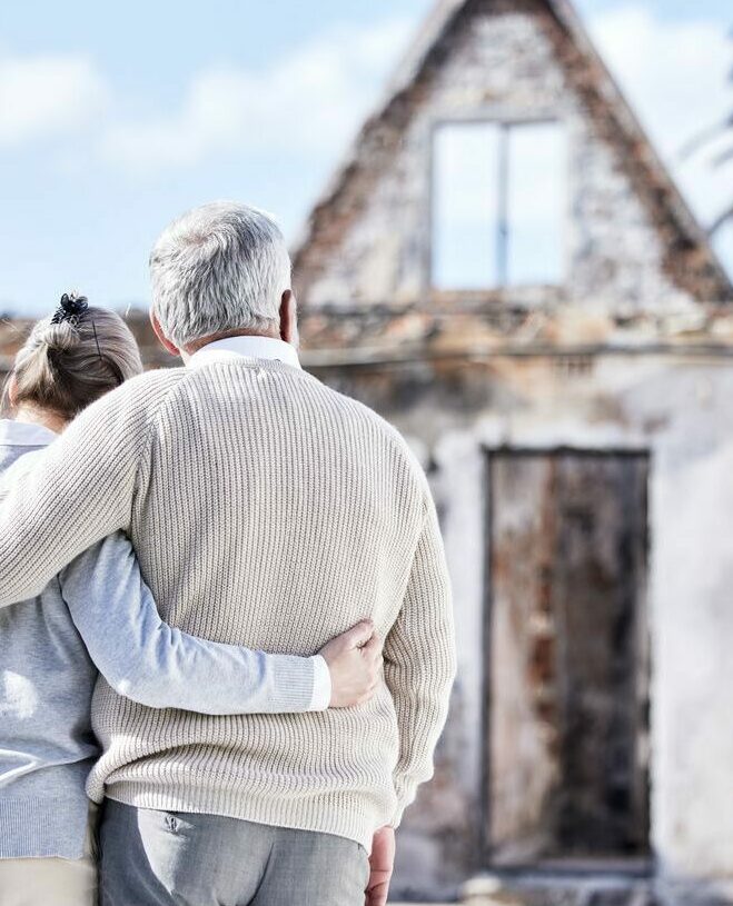 Shot of a senior couple comforting each other after losing their home to a fire